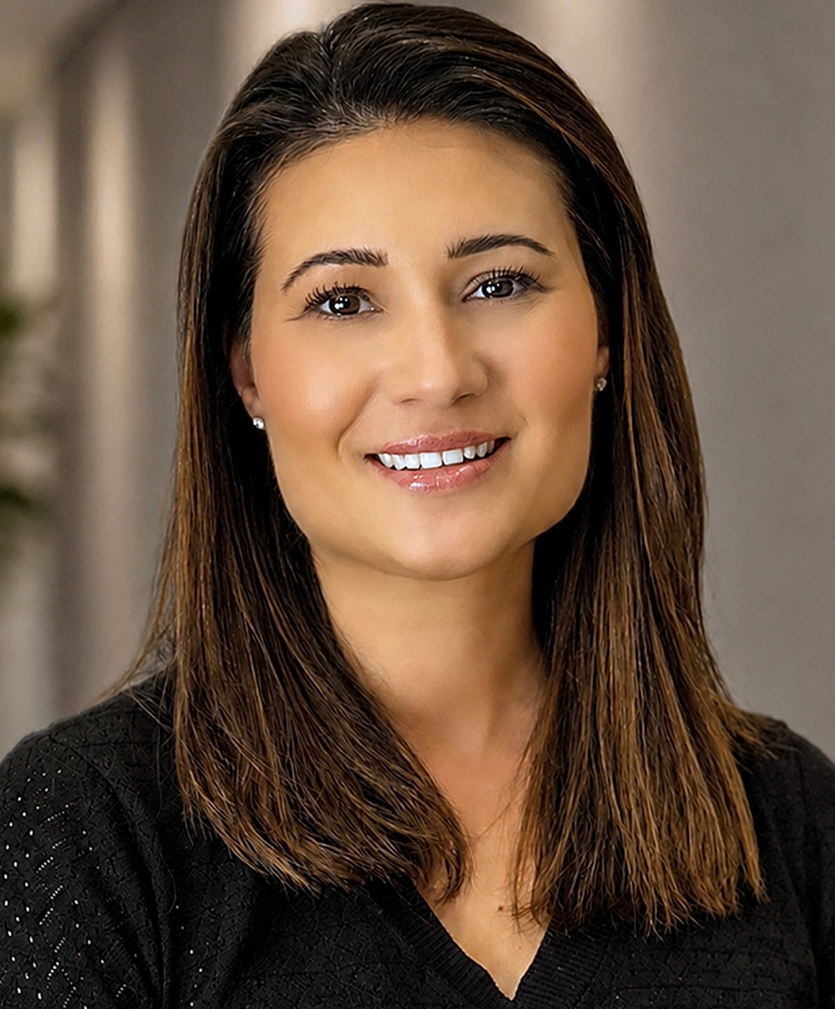 Smiling woman with long hair against neutral background