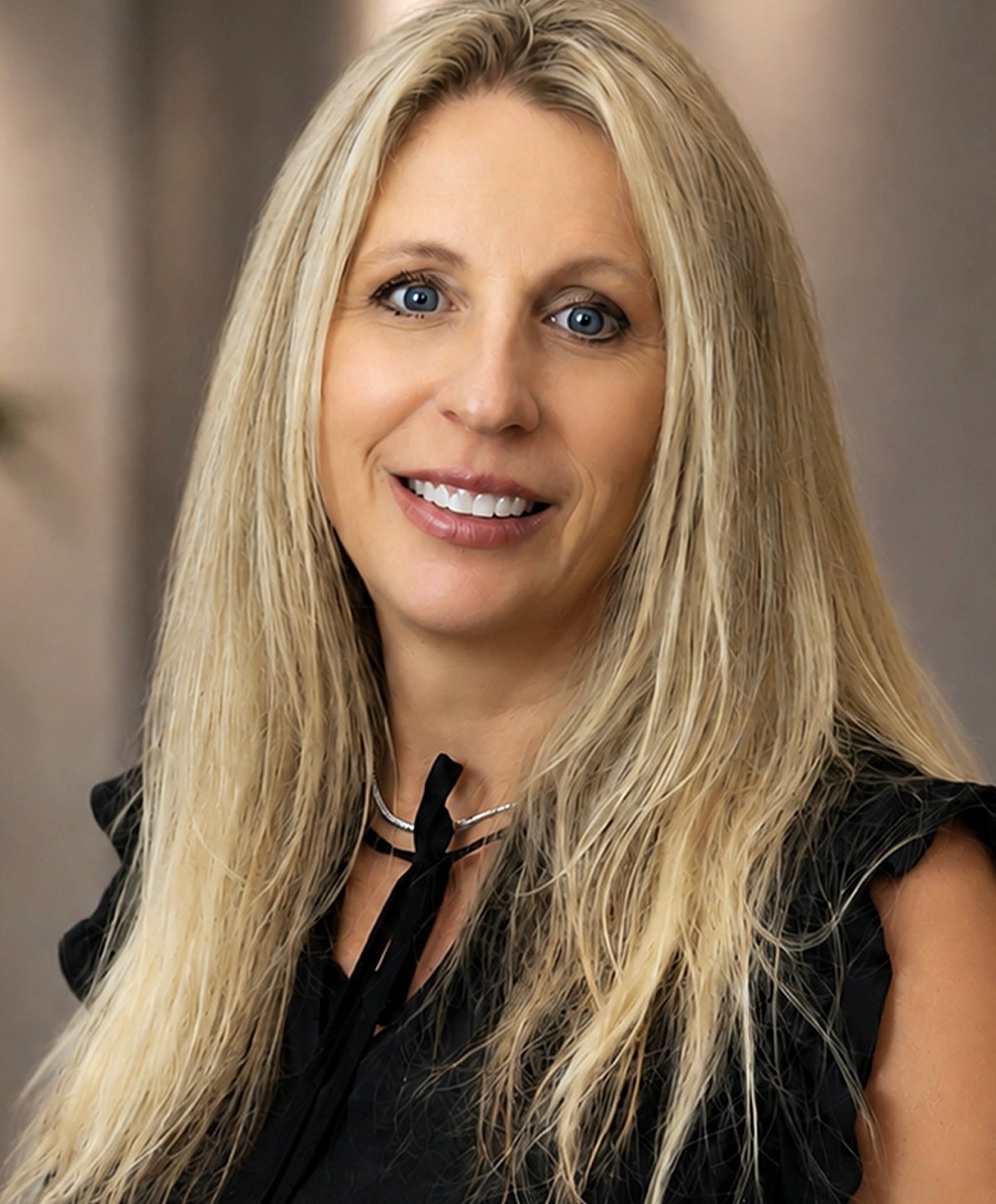Professional woman with long blonde hair smiling.