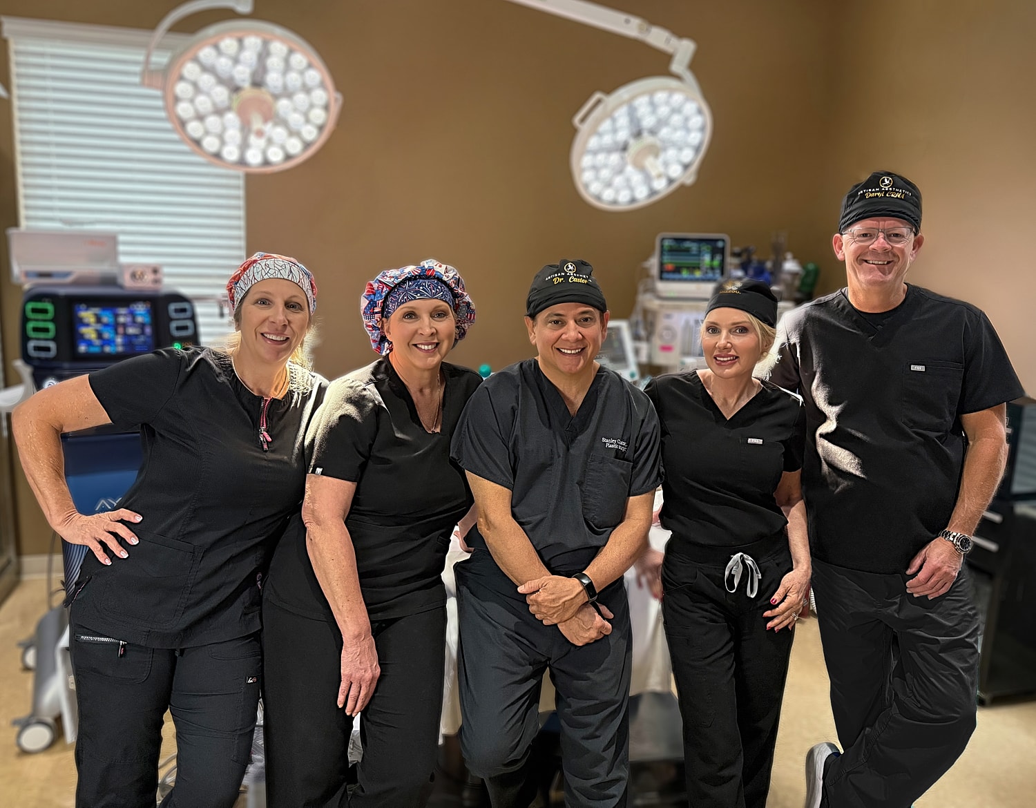 Medical team posing in surgical environment.
